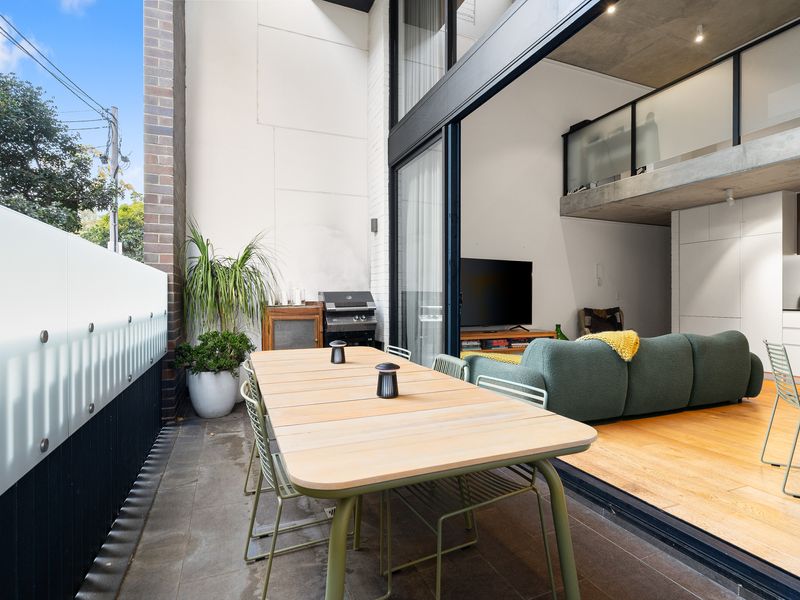 Spacious open-plan living area showing the dining table, lounge seating, and high ceilings.