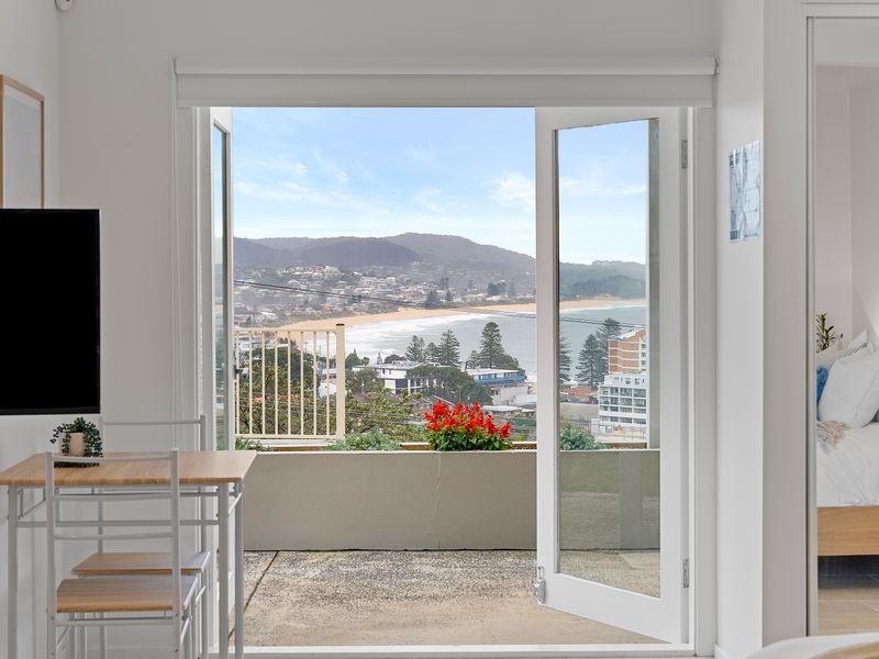 Sliding glass doors opening from the interior living space out onto a scenic outdoor balcony.