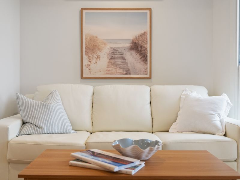 Comfortable living room seating area arranged with a light-colored sofa and decorative artwork.