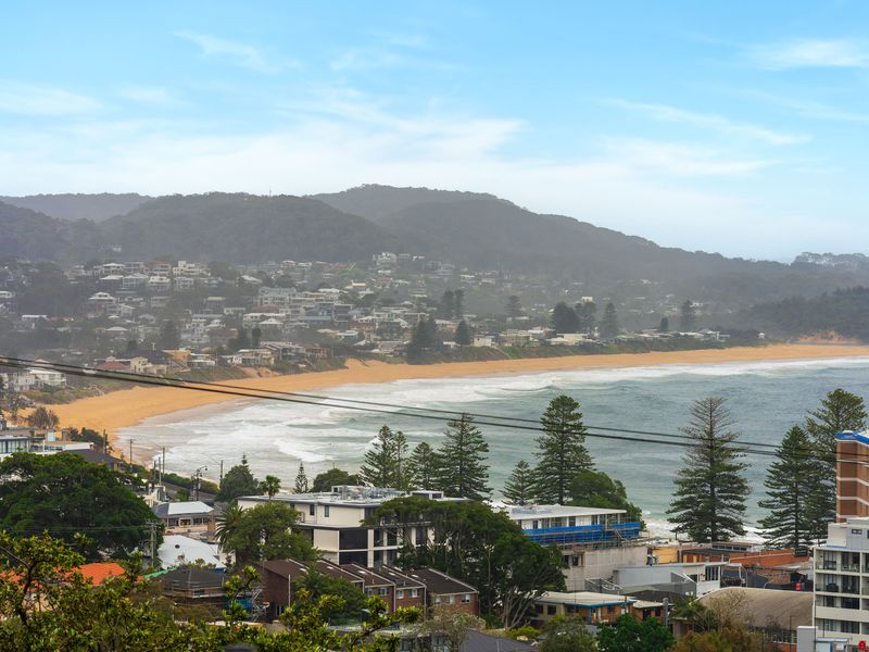 High-angle coastal panorama overlooking the beach, rolling hills, and surrounding neighborhood.