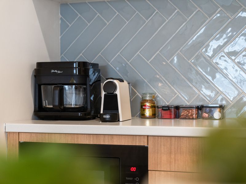 Kitchen prep counter featuring an espresso machine and modern appliances.