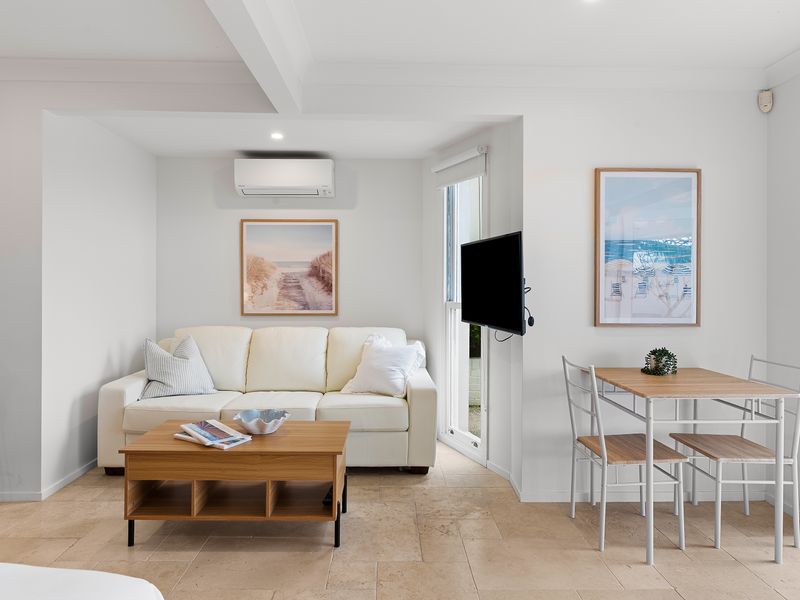 Cozy living room lounge space arranged around a coffee table facing the television.