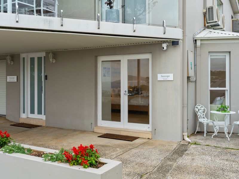 Covered ground-floor outdoor patio entrance with large glass doors and white paneling.