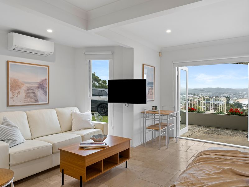 Open-plan interior view connecting the living room, dining space, and balcony access.