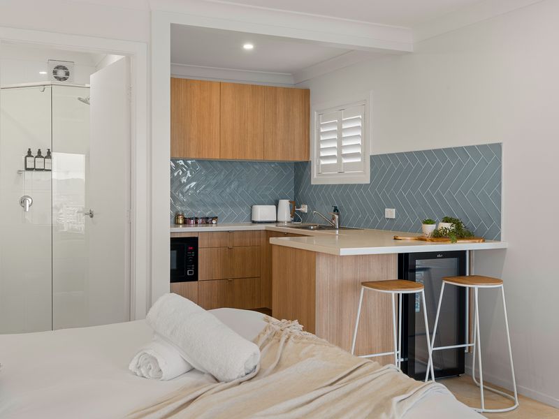 Bedroom view highlighting the cozy bed setup and proximity to the apartment entrance.
