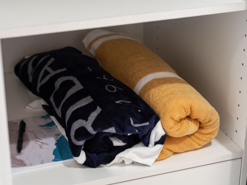 Shelf storage neatly holding rolled towels and beach gear essentials.