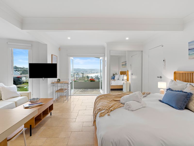 Bright and airy open-plan living area featuring a neutral sofa and direct access to the balcony.