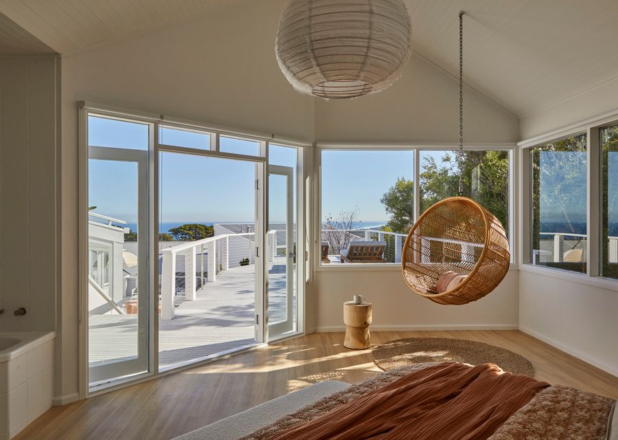Bedroom seven with hanging chairt and large balcony with sun loungers 