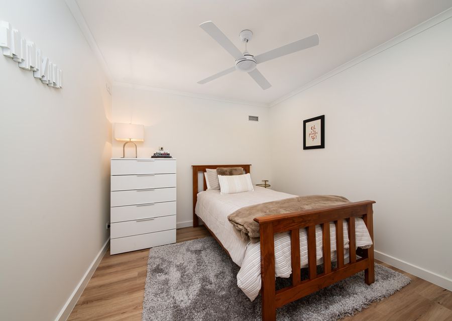 Single bedroom with ceiling fan on ground floor next to master