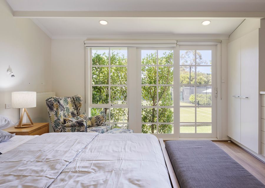 Bedroom two with king bed and views over the tennis court 