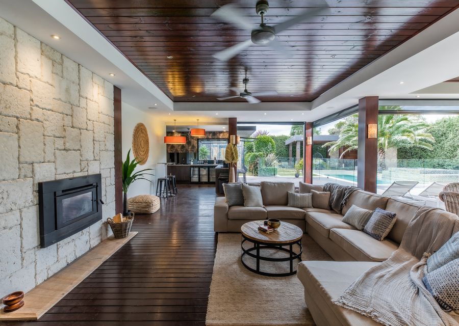 Outdoor living and dining with outdoor blinds. views of the pool, outdoor fireplace