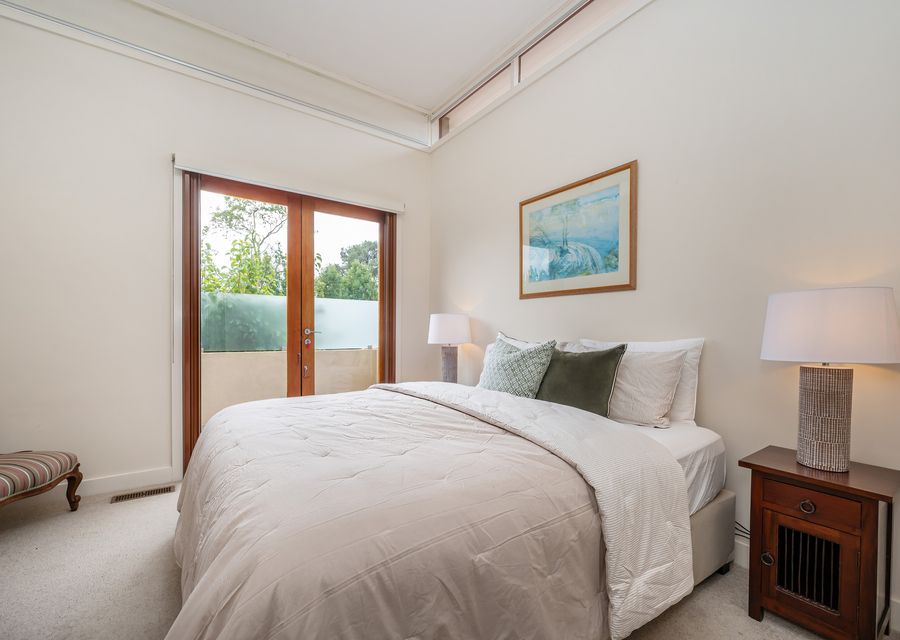 Master bedroom styled with comfort in mind, double doors onto balcony access