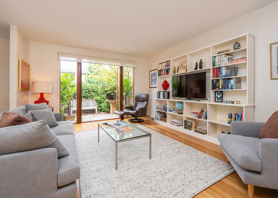Light and bright open plan living space with smart TV and large doors onto courtyard