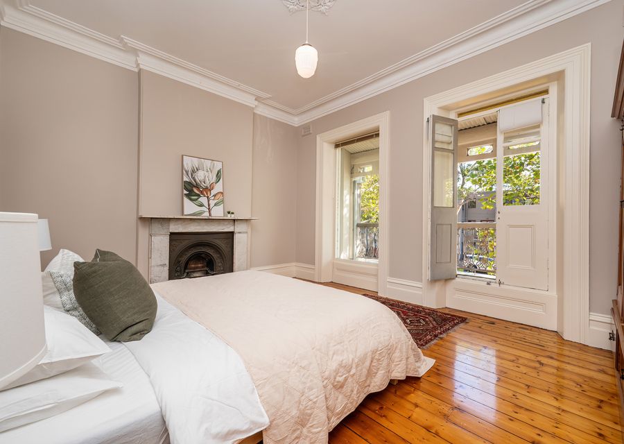 Bedroom one with balcony access and ornamental fireplace 