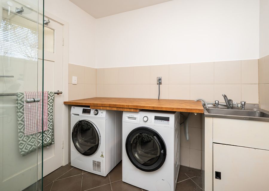 Laundry in bathroom with front loading washing machine and separate dryer