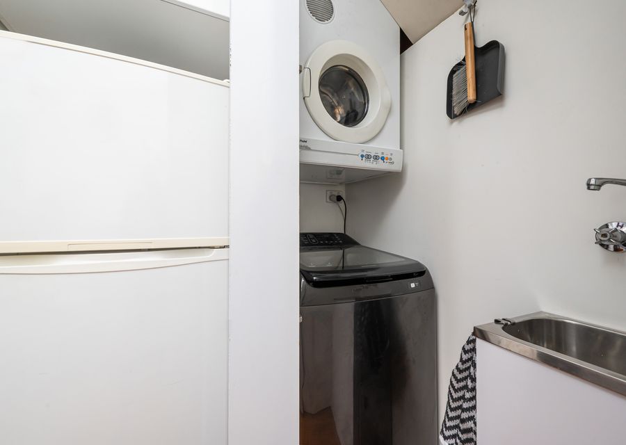Laundry located to the right of the fridge in kitchen  with washing machine and dryer 
