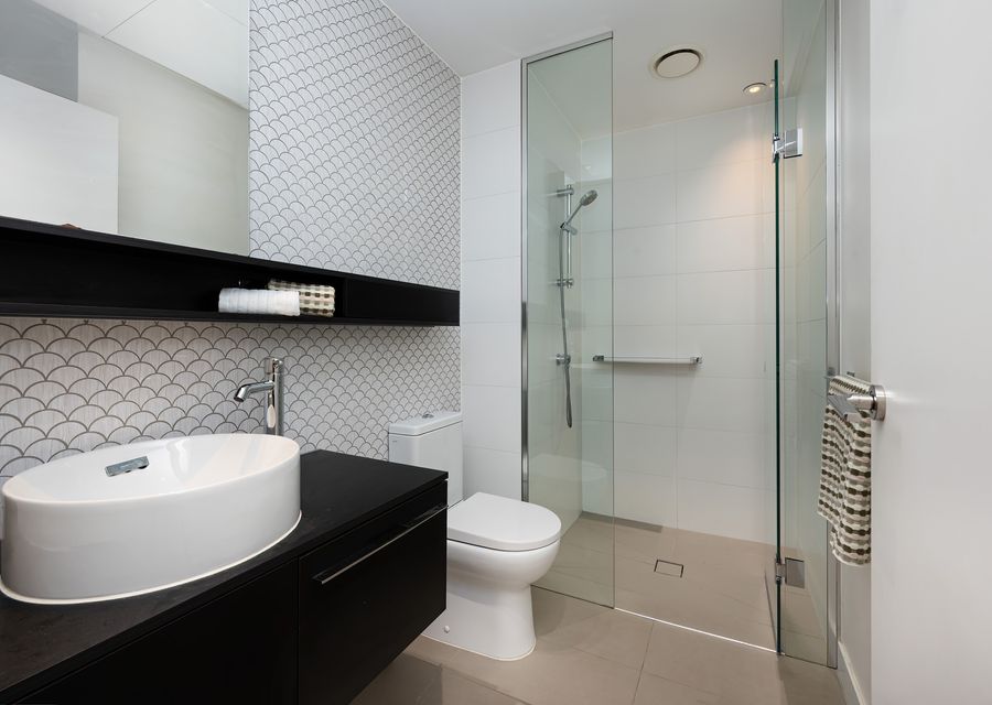 Bathroom with walk in shower, single vanity and toilet