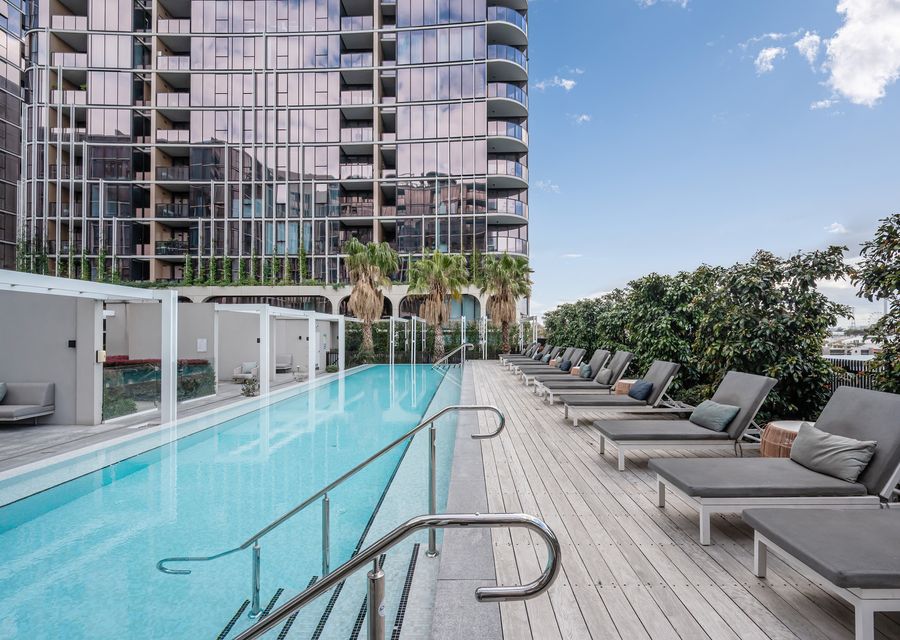 Large shared solar heated pool with plenty of pool side lounges and seating