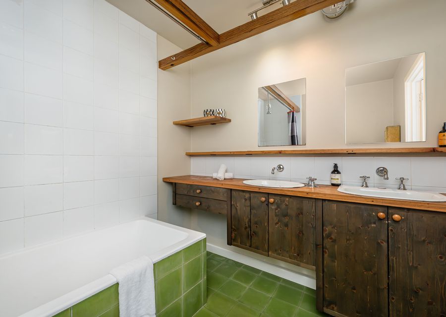 Family bathroom with double vanity and shower over bath