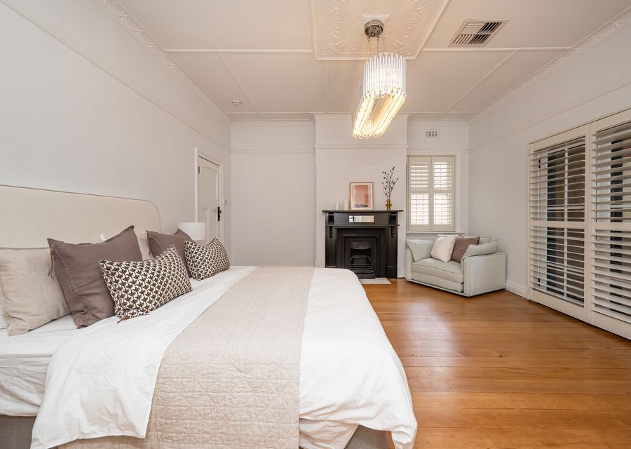 Master bedroom with ensuite, king bed and king single fold out couch with balcony access and ornate fireplace 