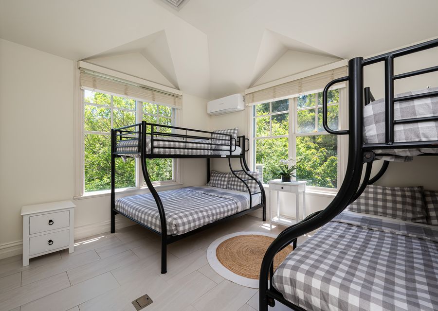 Bedroom with bunk beds, double at the bottom and single bunks on top 