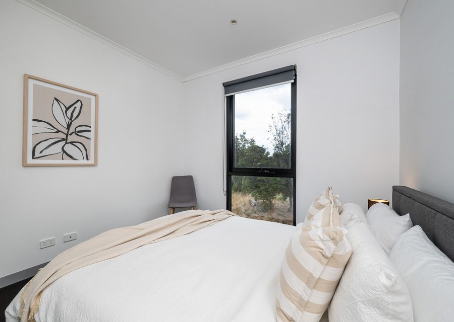 Bedroom one with queen bed and nature reserve view 