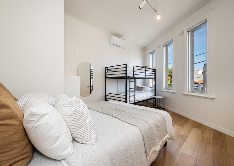 Bedroom four with queen bed and king single bunk. This room will change into the living room with two fold out couches in July 2026