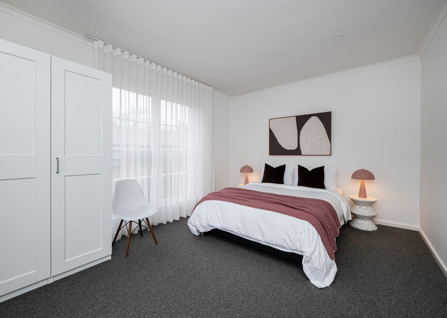 Spacious bedroom with queen bed and wardrobe.