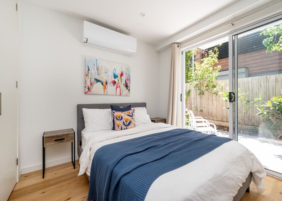 Bedroom 1 with split system and large class doors onto sunny courtyard
