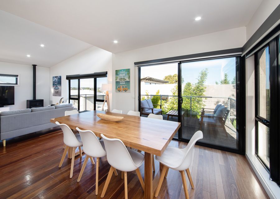 DIning area along with open plan living and kitchen and access to deck