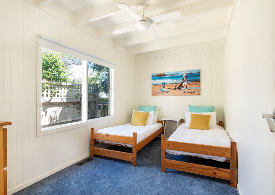 Bedroom four has 2 single beds and a ceiling fan