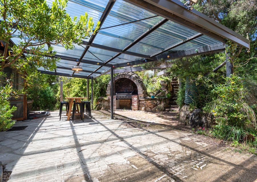 Backyard dining and BBQ area with the secret stairs to the viewing platform above