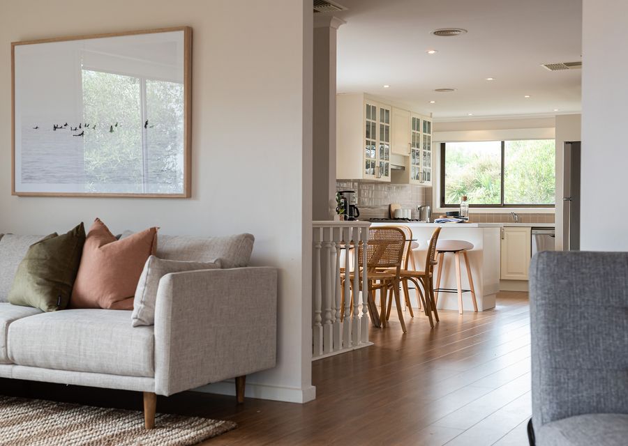 Comfy sofa with a peak of the kitchen and dining