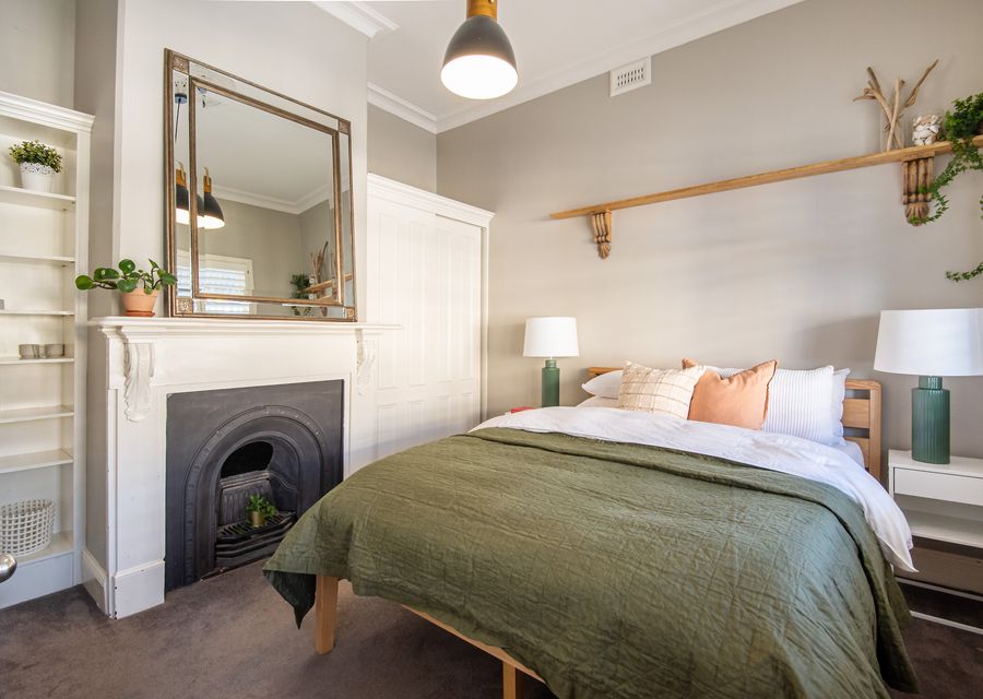 Bedroom one with queen bed and ornamental fireplace 