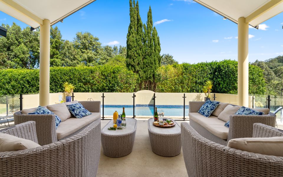 outdoor dining and entertainment area of south coast accommodation overlooking a pool