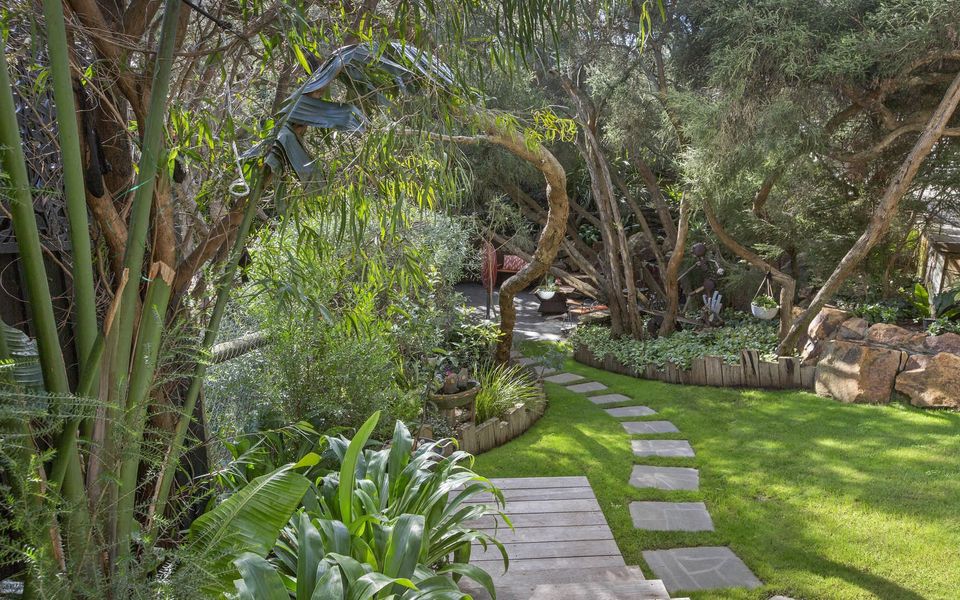 Landscaped front garden with fire pit and seating area. (Fire pit use subject to local fire regulations)