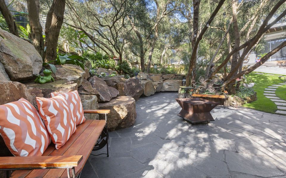 Landscaped front garden with fire pit and seating area. (Fire pit use subject to local fire regulations)
