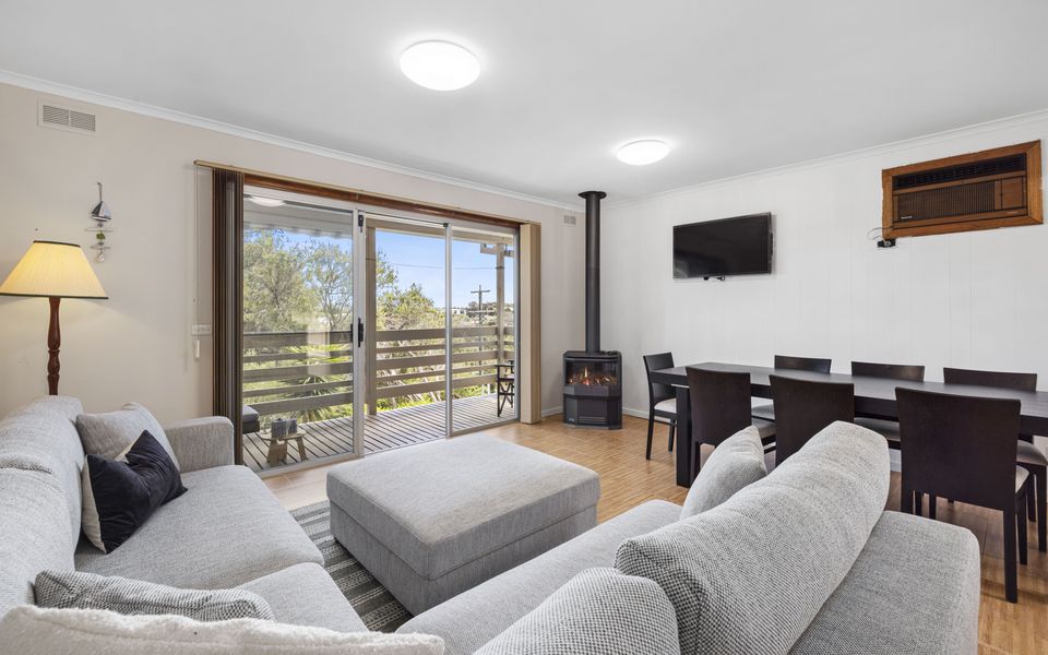 Open plan living/dining area with cosy fireplace and air conditioner