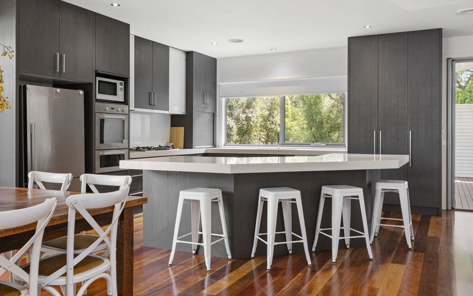 Fully equipped kitchen with stone bench tops and stainless steel appliances