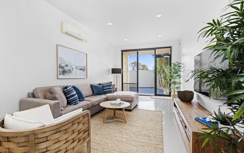 Living room with coastal touches, smart TV, large comfy couch and access to the heated pool and spa