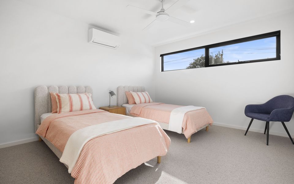 Bedroom two with single beds, split system and ceiling fan