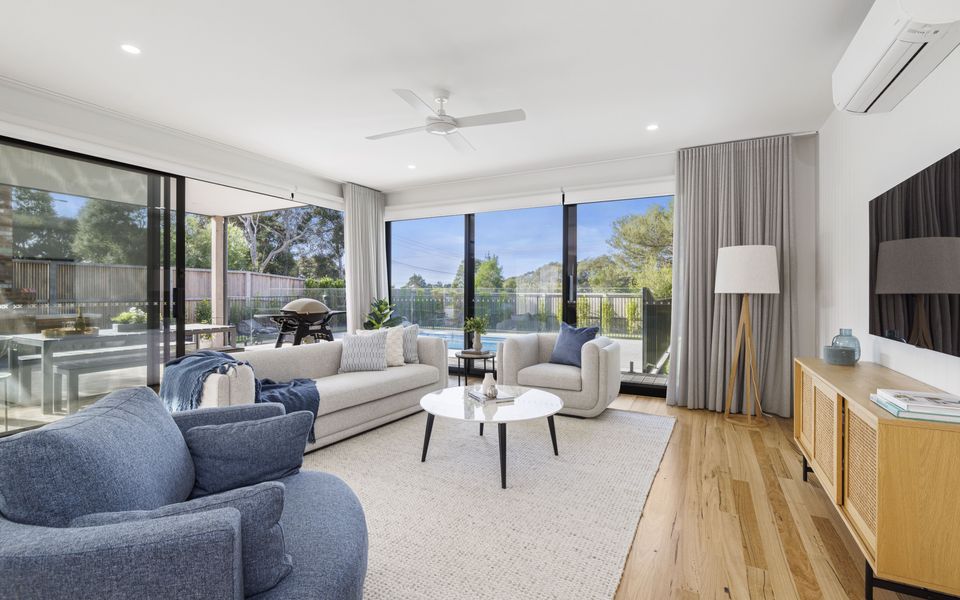 Sun-drenched lounge with plush seating, large windows, and direct access to the pool area