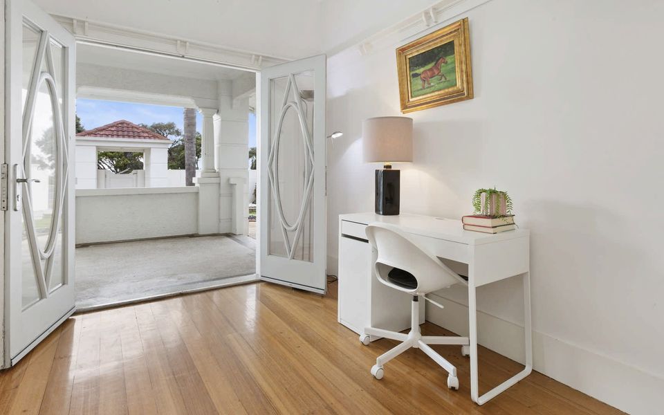 Study with doors opening to a covered patio, perfect for catching the coastal breeze.