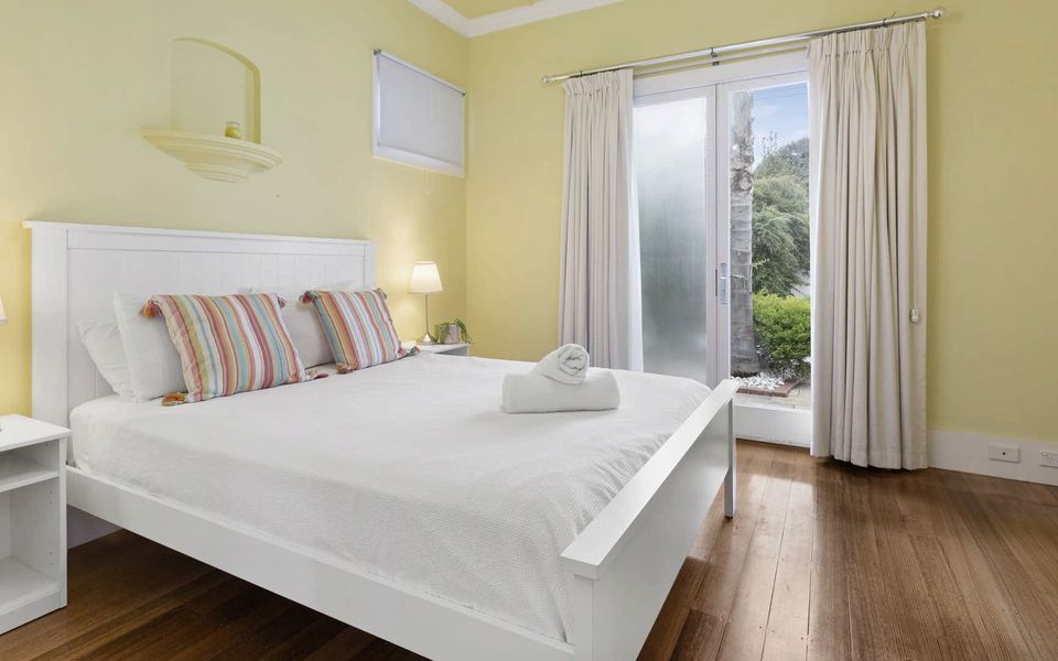 Bedroom 3 with Queen bed and French windows opening on to the landscaped garden.