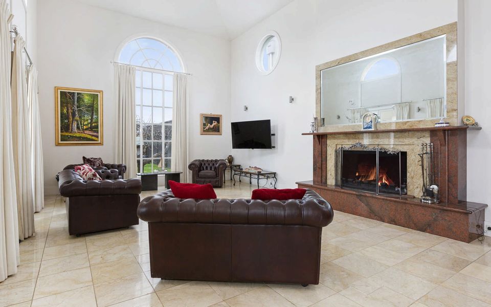 Large light filled family living area perfect for relaxing with a decorative fireplace (not functional).