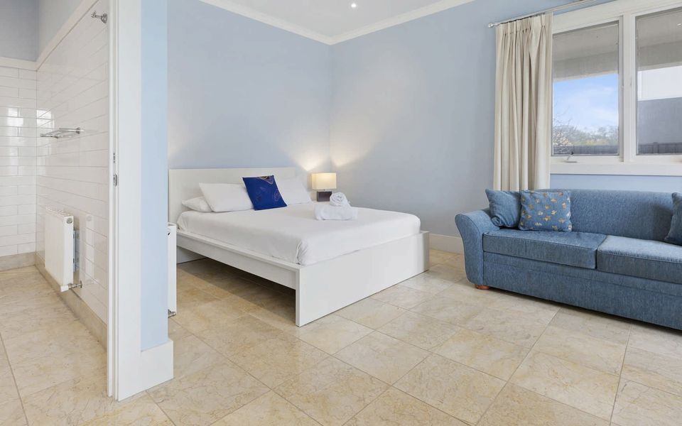 Queen bed and couch in studio, linen is provided.