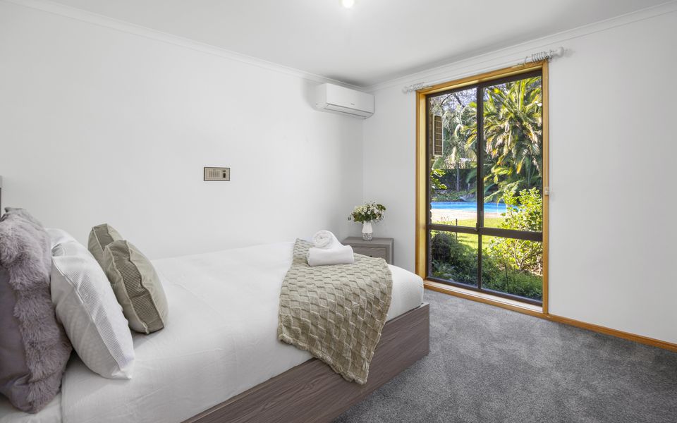 Comfortable third bedroom featuring a Queen bed, wardrobe, and air conditioning/heating.