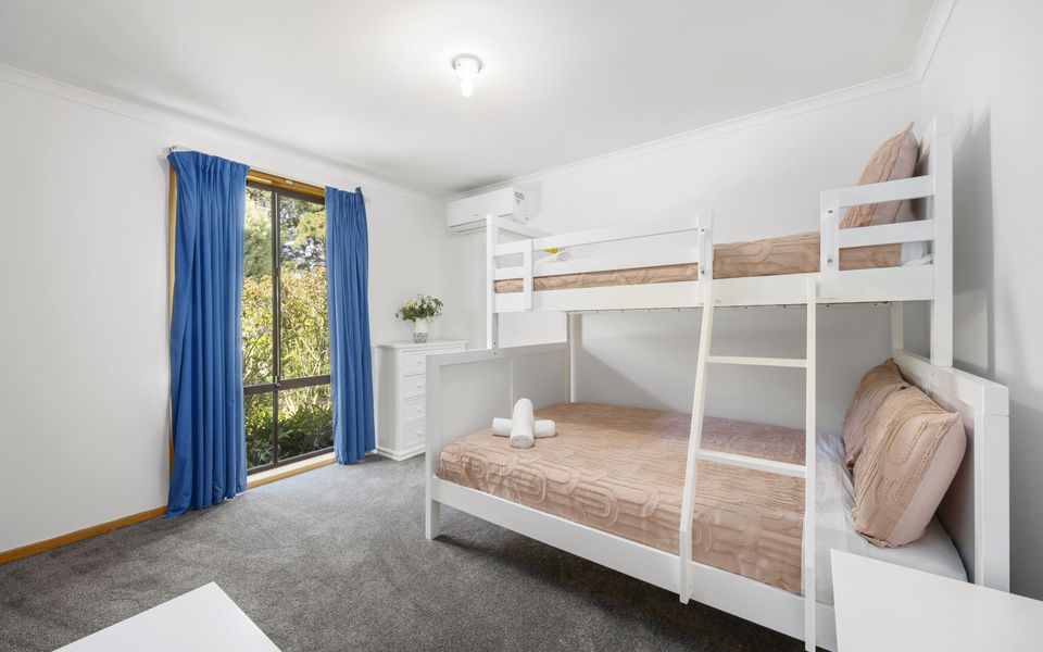 Bedroom 2 featuring a tri-bunk (double on bottom and single on top), wardrobe, and air conditioning/heating.