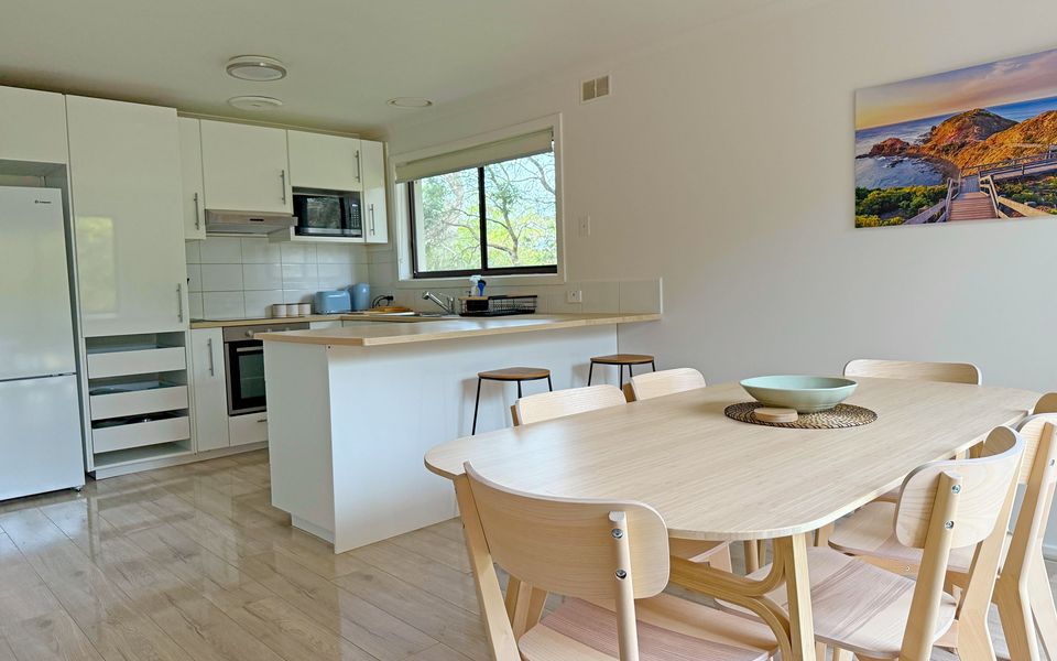 Dining area comfortably seats six, and the kitchen bench with two stools is ideal for breakfast or quick meals.