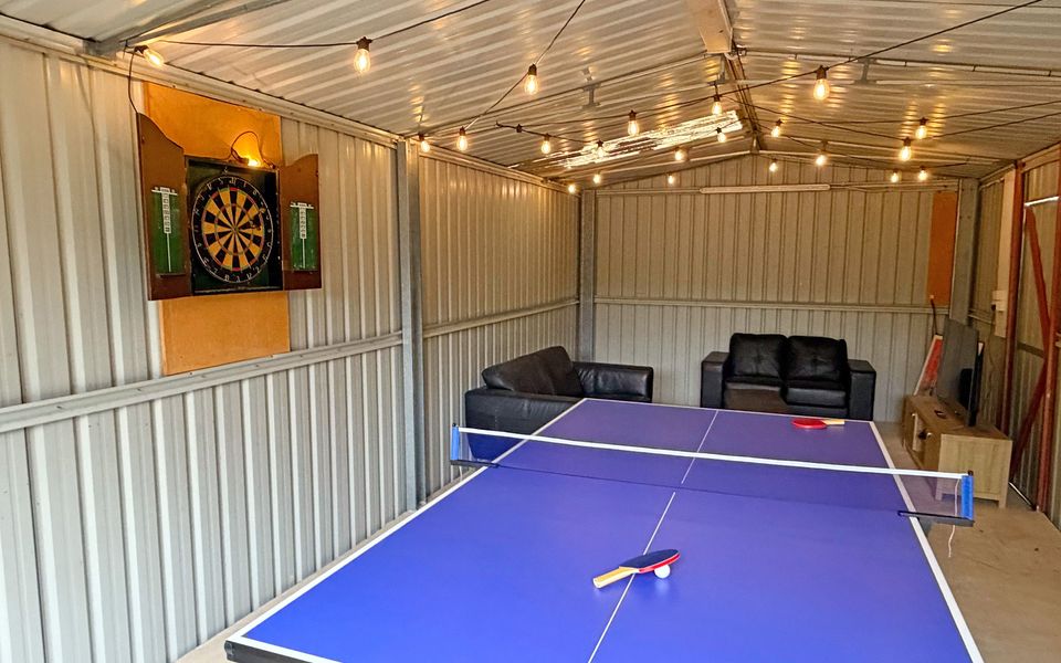 Enjoy the games room, complete with a Smart TV, couches, dartboard, and table tennis.